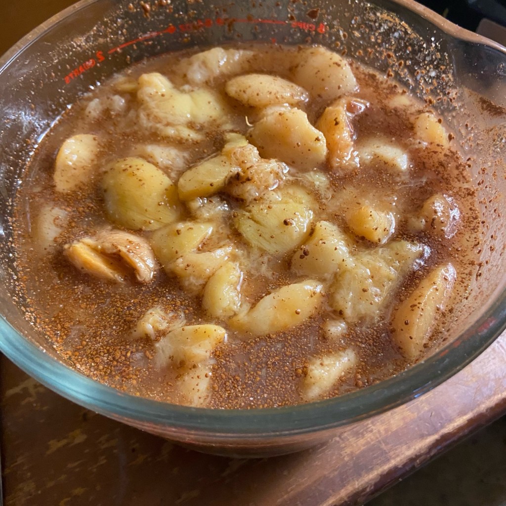 Fresh peach slices mixed with sugar, nutmeg, cinnamon, and vanilla.