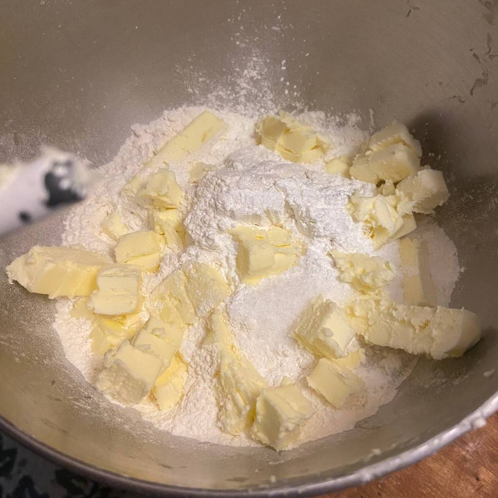 pieces of butter in flour mixture in a mixer bowl